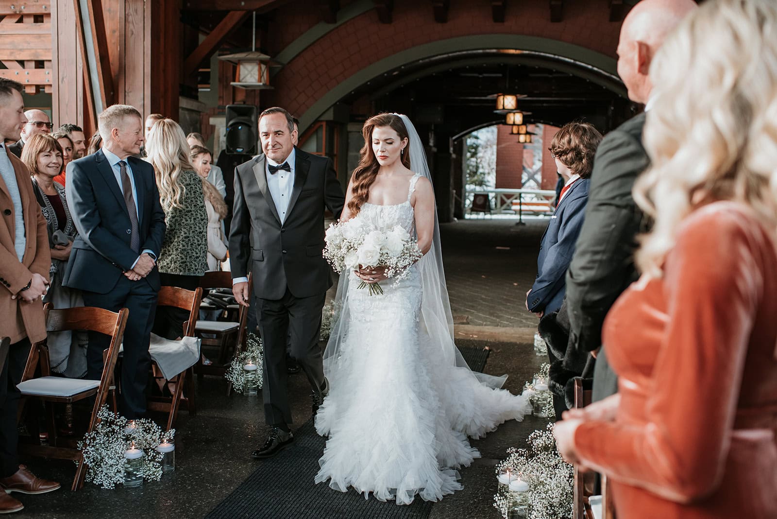 Bride walks down the aisle with her father at Nita Lake Lodge in Whistler BC